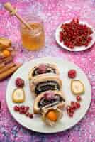 Gratis foto bovenaanzicht in de verte roll cakeplakken met verschillende soorten fruit in witte plaat met honing op het gekleurde bureau cake koekje zoet fruit