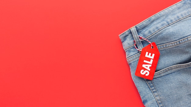 Bovenaanzicht jeans met verkooplabel op rode achtergrond