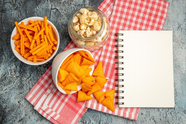 Bovenaanzicht kaas cips met beschuit en popcorn op lichte ondergrond