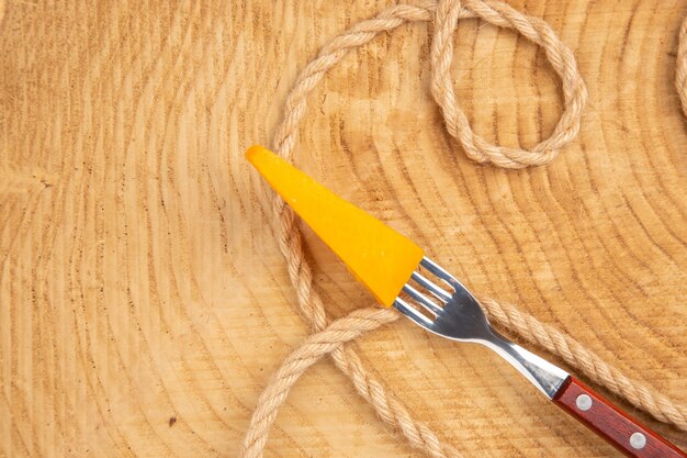 Bovenaanzicht kaas op vork touw op houten tafel