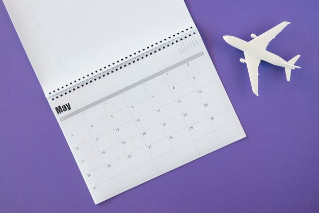 Bovenaanzicht kalender en wit speelgoed vliegtuig