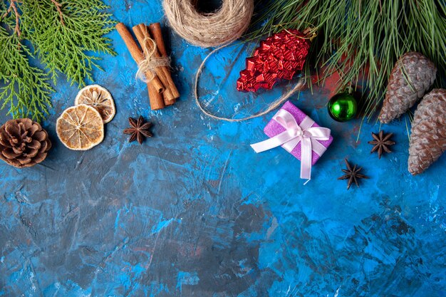 Bovenaanzicht kerstcadeaus dennenboom takken kegels anijs op blauwe achtergrond vrije plaats