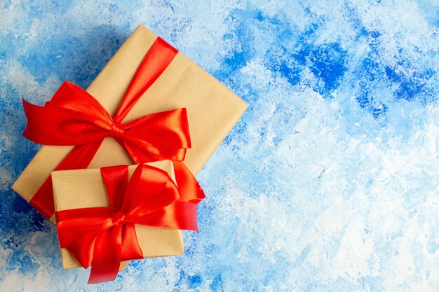 Bovenaanzicht kerstcadeaus gebonden met rode strik op blauwe tafel met vrije plaats