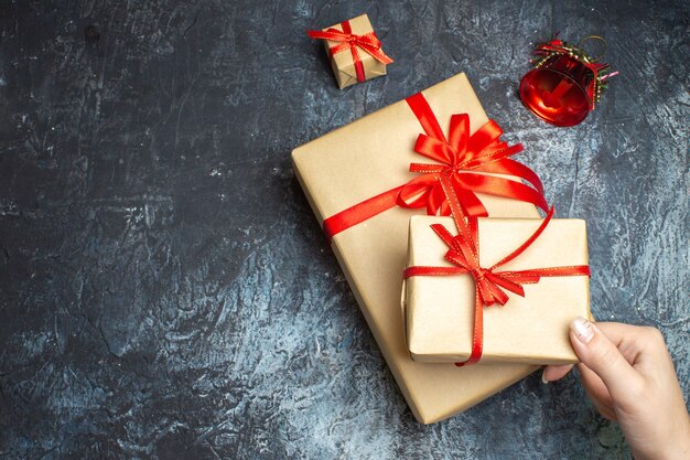 Bovenaanzicht kerstcadeautjes met rode strikken op licht-donkere achtergrond
