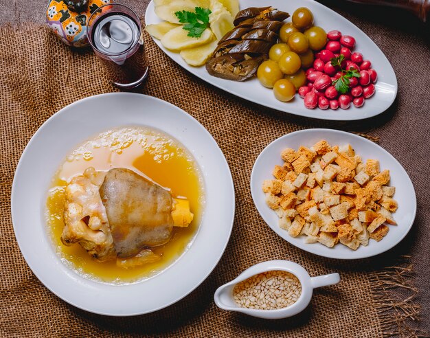 Bovenaanzicht khash met ingelegde aubergine kornoelje komkommer kersenpruim brood beschuit azijn en knoflook