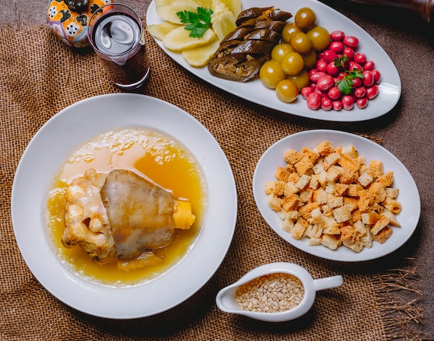 Bovenaanzicht khash met ingelegde aubergine kornoelje komkommer kersenpruim brood beschuit azijn en knoflook