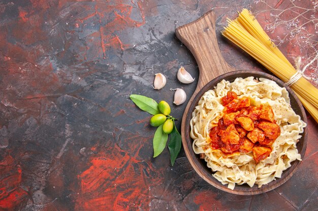 Bovenaanzicht kip met deeg pastaschotel op de donkere ondergrond schotel donkere pastadeeg