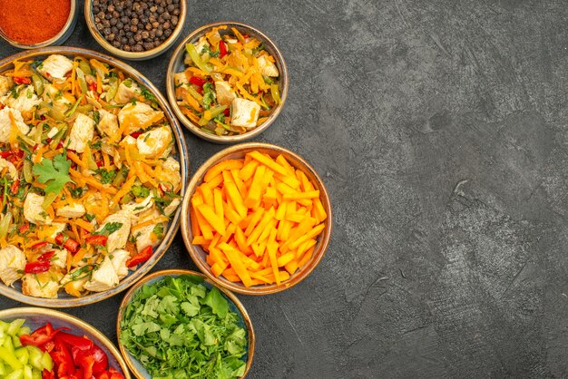 Bovenaanzicht kipsalade met groenten en greens op donkere tafel dieet gezondheid