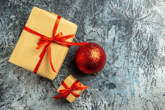 Bovenaanzicht klein geschenk gebonden met rood lint rode kerstboom bal op donkere achtergrond