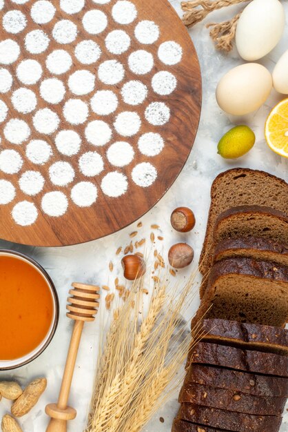 Bovenaanzicht klein rond deeg rond eieren gelei meel en donker brood op de witte achtergrond bak oven taart taart kleur ei melk ontbijt