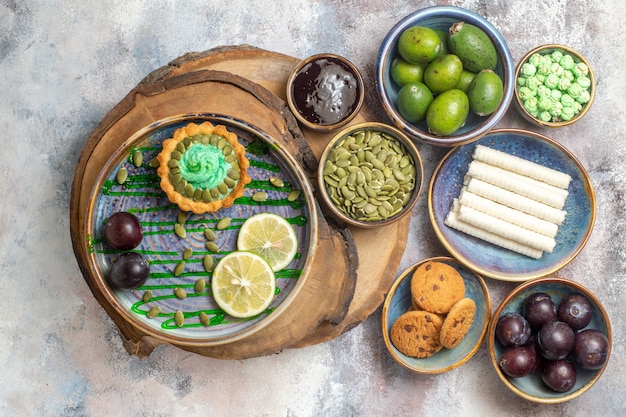 Bovenaanzicht kleine cake met fruit en snoepjes