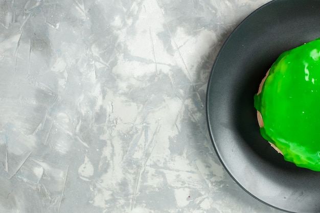 Bovenaanzicht kleine cake met groen suikerglazuur op een lichte witte achtergrond cake pie biscuit zoete suiker koekjes