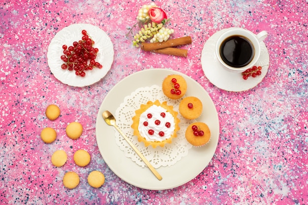 Bovenaanzicht kleine cake met roomkoekjes verse veenbessen samen met een kopje koffie en kaneel op het gekleurde oppervlak cake zoet