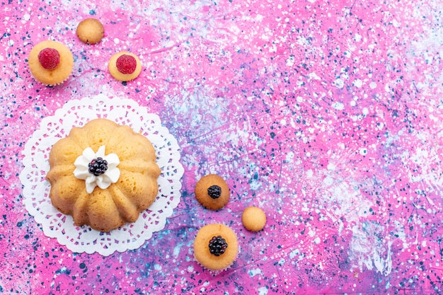 Bovenaanzicht kleine heerlijke cake met room en bessen op de heldere foto van het koekje van de koektaart bes zoete suiker