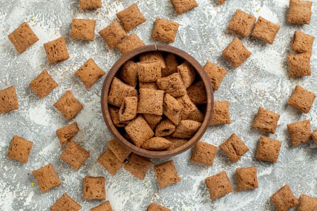 Bovenaanzicht kleine kussen vlokken zoete koekjes op witte oppervlakte kleur maaltijd ontbijt melk