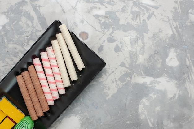 Bovenaanzicht kleine pijp koekjes met marmelade op lichte witte achtergrond cookie biscuit suiker zoete cake pie