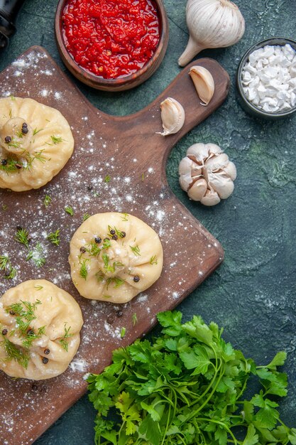 Bovenaanzicht kleine rauwe knoedels met tomatensaus en greens op donkerblauw oppervlak koken diner deeg gerecht maaltijd keuken vlees