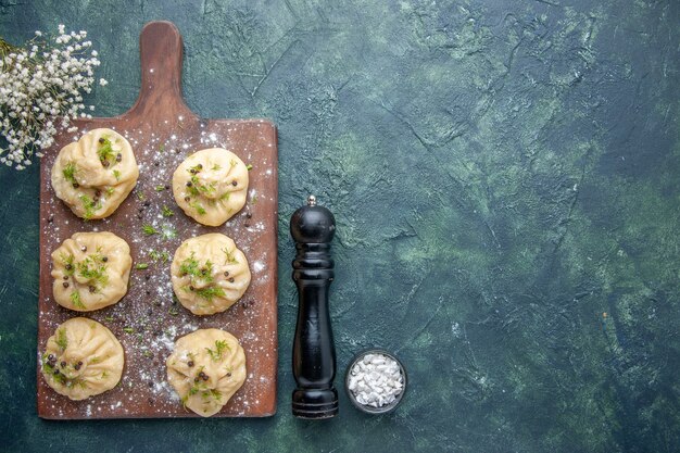 Bovenaanzicht kleine rauwe knoedels met vlees binnen op donkerblauw oppervlak vlees deeg keuken schotel cake diner maaltijd koken