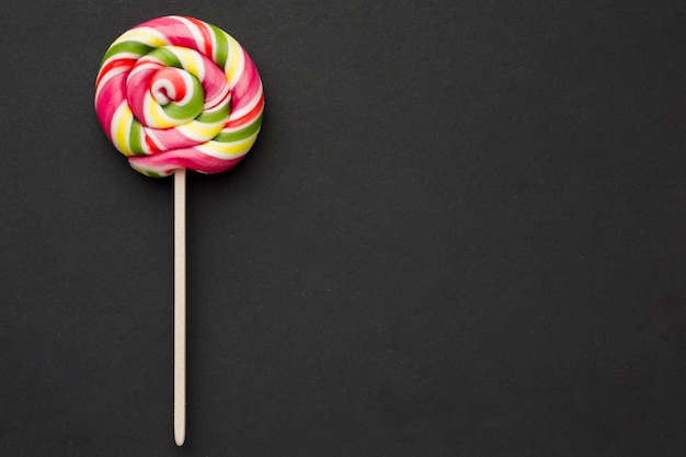 Bovenaanzicht kleurrijke lolly op zwarte tafel