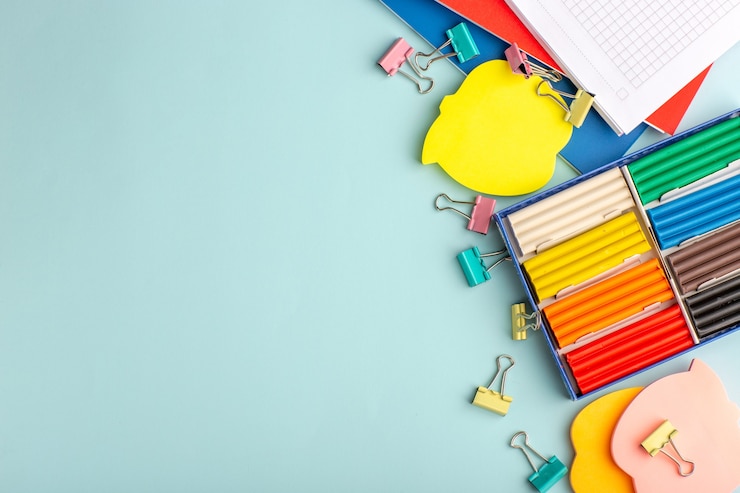 Gratis Foto bovenaanzicht kleurrijke plasticines met voorbeeldenboeken op blauwe muur kleur schoolkinderen kinderen boek