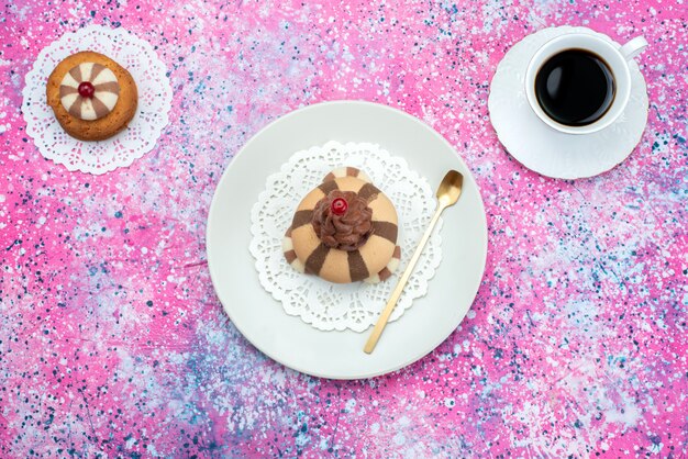 Bovenaanzicht koekje en cake met kopje koffie op de gekleurde achtergrond cake suiker zoete koffie