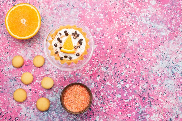 Bovenaanzicht koekjes en cake met oranje helft op het heldere oppervlak koekjeskoekje fruitcake suiker zoet