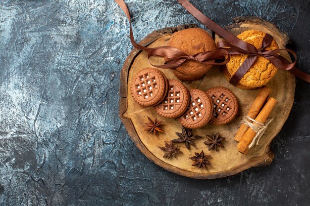 Bovenaanzicht koekjes en koekjes anijs kaneelstokjes op ronde houten bord op donkere tafel kopie plaats