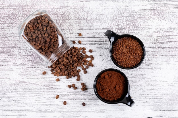 Bovenaanzicht koffiebonen en instant koffie op witte tafel