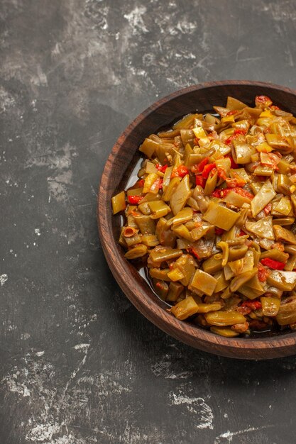 Bovenaanzicht kom smakelijk gerecht kom smakelijk gerecht sperziebonen en tomaten op de donkere tafel