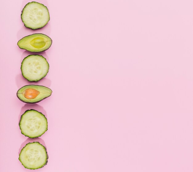 Bovenaanzicht komkommer plakjes en avocado met kopie ruimte
