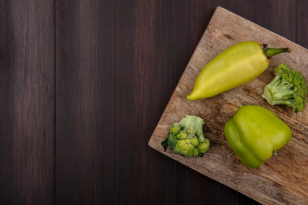 Bovenaanzicht kopie ruimte broccoli met groene paprika op snijplank op houten achtergrond