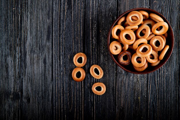 Bovenaanzicht kopie ruimte droge bagels in een kom op een zwarte houten achtergrond