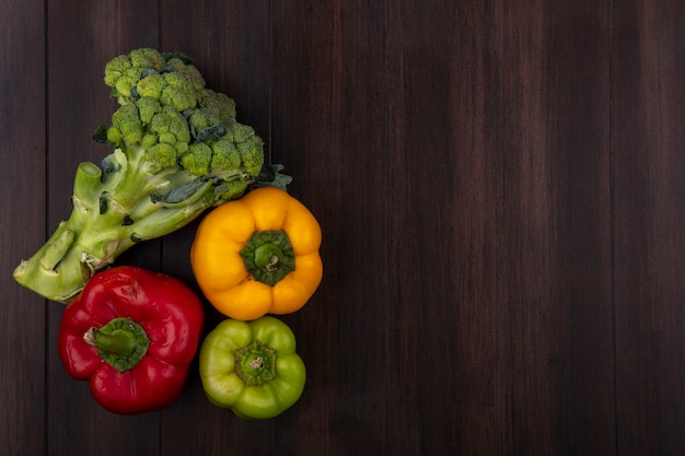 Bovenaanzicht kopie ruimte gekleurde paprika met broccoli op houten achtergrond