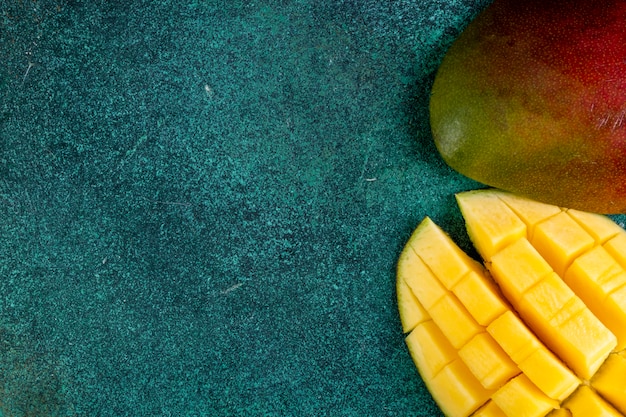 Bovenaanzicht kopie ruimte gesneden mango op groen