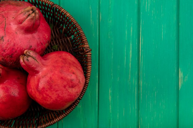 Bovenaanzicht kopie ruimte granaatappels in een mand op een groene muur