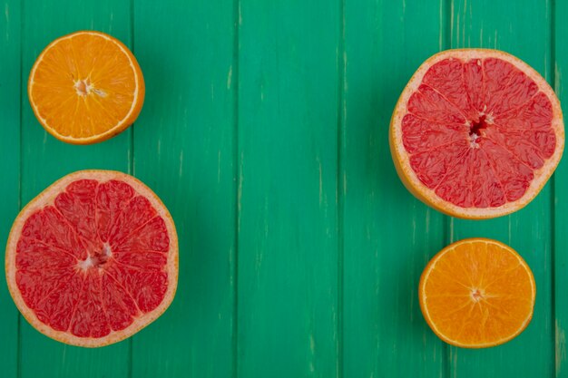 Bovenaanzicht kopie ruimte grapefruit helften met sinaasappelen op groene achtergrond