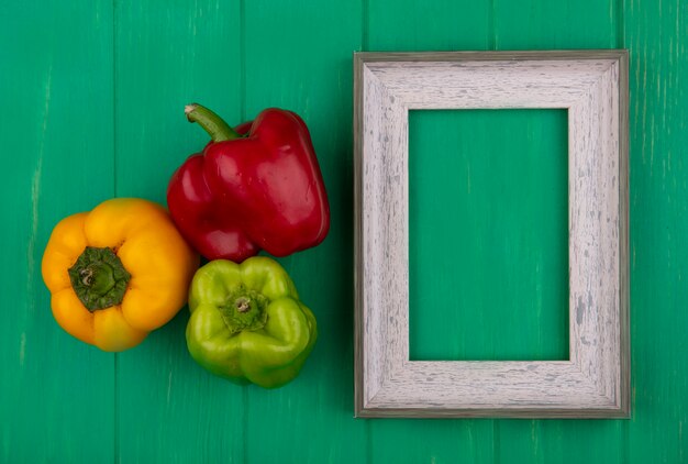 Bovenaanzicht kopie ruimte grijs frame met gekleurde paprika op groene achtergrond