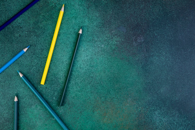 Bovenaanzicht kopie ruimte kleurrijke potloden op een groene achtergrond Gratis Foto