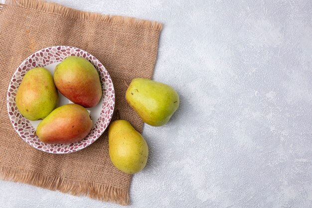 Bovenaanzicht kopie ruimte peren in een plaat op een beige servet op een witte achtergrond