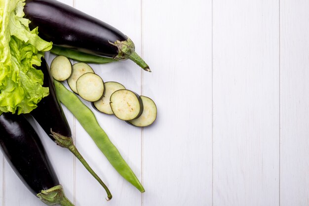 Bovenaanzicht kopie ruimte verse aubergines met groene loby en sla op een witte achtergrond