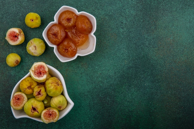 Gratis foto bovenaanzicht kopie ruimte vijgen en jam in schoteltjes op groene achtergrond