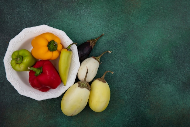 Bovenaanzicht kopie ruimte witte en zwarte aubergine met paprika op een bord op een groene achtergrond