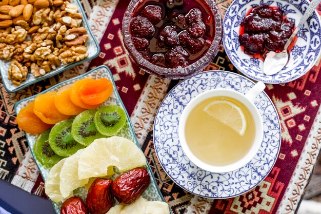 Bovenaanzicht kopje groene thee met een schijfje citroen gedroogd fruit en aardbeienjam