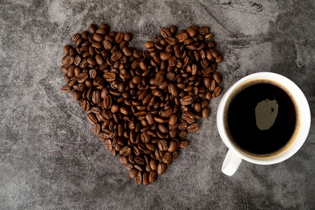 Bovenaanzicht kopje koffie met geroosterde bonen