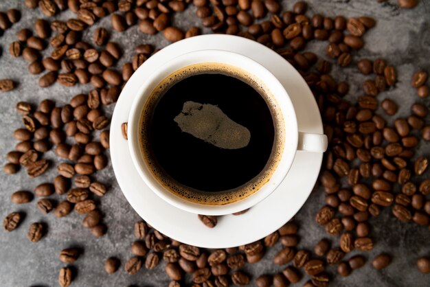 Bovenaanzicht kopje koffie met geroosterde bonen