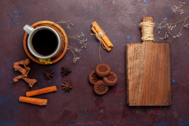Bovenaanzicht kopje thee in plaat en kopje op donkere achtergrond thee drinken kleurenfoto zoet