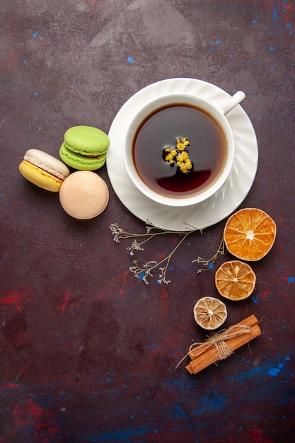 Bovenaanzicht kopje thee in plaat en kopje op donkere achtergrond thee drinken kleurenfoto zoet