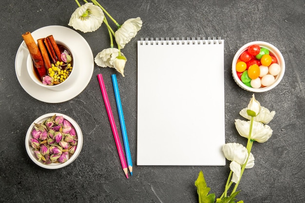 Bovenaanzicht kopje thee met bloemen en potloden op grijze achtergrond thee drinken kleur bloem smaak