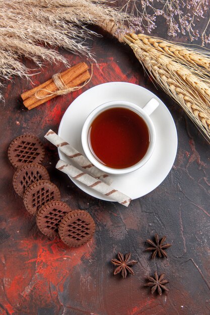 Bovenaanzicht kopje thee met choco cookies op donkere tafel cookie koekjesthee