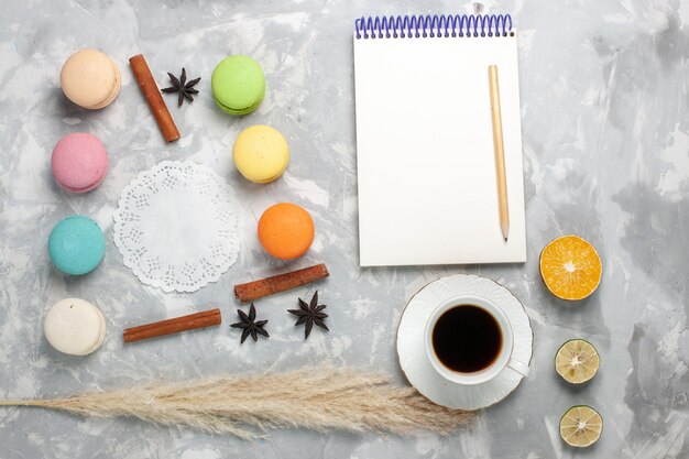 Bovenaanzicht kopje thee met Franse macarons op wit